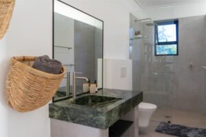 Modern en-suite bathroom featuring sleek finishes and premium amenities in Room 5 at Views Over Wilderness guesthouse.